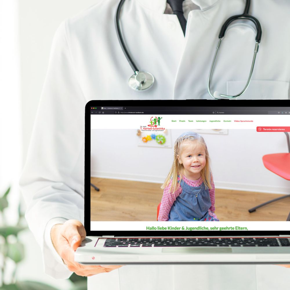 Arzt hält Laptop mit der neuen Webseite der Kinderäztin in Hardheim